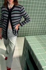 Cardigan vestido azul con rayas horizontales en tonos celeste, verde y beige. Tiene cuello redondo, mangas largas y cierre frontal con botones.