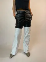 Pantalón de cuero de corte recto y tiro alto, con diseño bicolor: negro en la parte superior y blanco en la inferior.