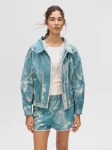 Short biker ajustado de lycra con estampado abstracto y difuminado en tonos verdes, naranjas, azules y rosados. Presenta costuras visibles en contraste y un pequeño logo bordado en la pierna derecha.