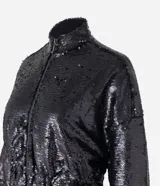 Campera bomber cropped de lentejuelas negras, con cuello tradicional, cierre delantero por cremallera y mangas largas.