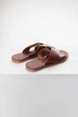 Sandalias bajas de cuero azul con tiras anchas cruzadas sobre el empeine y suela plana color madera.