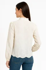 Camisa blanca de algodón con cuello mao con volados y mangas largas abullonadas.