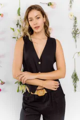 Chaleco negro de lino con escote en V y cierre frontal con botones.