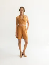 Short color ocre de tiro alto con pinzas delanteras y bolsillos laterales.
