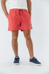 Short de baño liso color salmón con cintura elástica ajustable con cordón negro, dos bolsillos delanteros y uno trasero.
