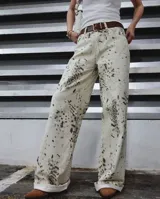 Pantalón de jean de tiro alto con estampado abstracto en tonos beige y marrón.