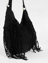 Cartera bandolera de estilo boho con flecos largos en los laterales. Cuenta con una correa ajustable con hebilla y herrajes metálicos en tono bronce.