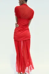 Vestido midi rojo de tul con cuello alto y mangas sisa semitransparentes. Interior con escote pico y tirantes finos ajustables. Tejido combinado a tono, detalle de frunces y cierre lateral con cremallera oculta.
