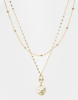 Collar corto dorado de doble cadena, una con bolitas y otra con dije redondo con diseño místico.