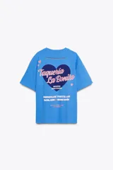 Camiseta celeste de algodón con corte oversize, cuello redondo, manga corta con hombro caído y estampado frontal con texto 'Taquería La Bonita' y un corazón.