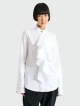 Camisa blanca de popelina con cuello mao, detalle de volado vertical en el frente y puños anchos con botones dorados.
