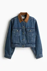 Campera de denim azul con cuello de pana marrón, botones metálicos dorados, canesú delantero y trasero, corte holgado, hombros caídos, puños abotonados, bolsillos laterales discretos y bolsillos superiores con solapa y botón.