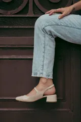 Zapatos estilo Mary Jane color beige, confeccionados en cuero, con taco cuadrado de 6 cm y tira con hebilla sobre el empeine.