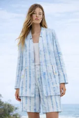 Camisaco oversized de algodón y lino color blanco con rayas verticales celestes. Tiene cuello camisero, manga larga y largo medio.