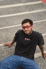 Remera negra de manga corta con cuello redondo y estampado de tres hongos rojos y blancos en el pecho.