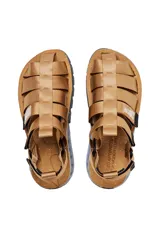 Sandalias con tiras de tela color beige, suela gruesa con detalles geométricos y ajuste con velcro.