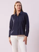 Camisa blanca de gasa, marca Sioni, con cuello con solapa, abertura central con botones y mangas largas con puño y botón.