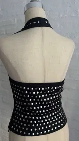 Top negro con lunares plateados, escote halter y espalda descubierta.
