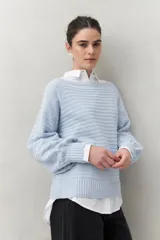 Sweater negro tramado de silueta relajada, con combinación de texturas en el tejido y mangas abullonadas con puños elastizados.