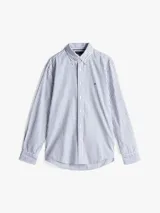 Camisa de mangas largas a rayas verticales azules y blancas, confeccionada en popelín de puro algodón con tecnología Flex que le confiere elasticidad. Tiene cuello abotonado, puños redondeados con botón y logo de Tommy Hilfiger bordado en el pecho.