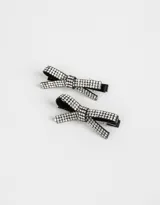Set de dos hebillas para el pelo tipo piquitos, con moño de tela negra y apliques de strass plateado.