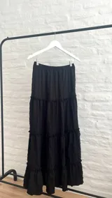 Pollera larga de color negro con elástico en la cintura.