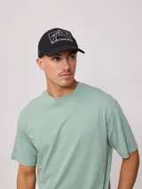Gorra azul marino con visera, de lona de algodón y malla trasera. Estampado frontal con el logo de la marca Rusty.