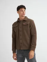 Camisaco de sherpa color beige con botones y bolsillos con solapa en el pecho.
