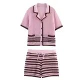Conjunto tejido de short y camisa a rayas horizontales rosas y marrones. La camisa es de manga corta, con cuello tipo polo y bolsillos frontales. El short tiene cintura elastizada con cordón ajustable.