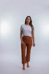 Pantalón de vestir color marrón, de corte recto, con bolsillos laterales y traseros. Se ajusta a la cintura con cinturón de cuero marrón.