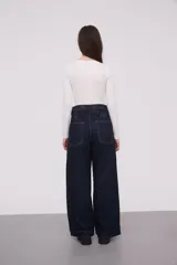 Pantalón de mezclilla azul oscuro de corte amplio, con diseño de bolsillos frontales.