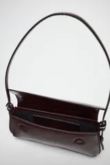 Bolso de hombro color borgoña con efecto acharolado, solapa con cierre magnético y asa ajustable.