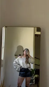 Blusa de manga larga con escote bote, confeccionada en tejido metalizado dorado suave.