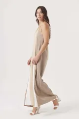 Mono largo de diseño holgado con breteles finos y escote en V. Presenta un diseño tricolor con bloques verticales en beige, negro y blanco.