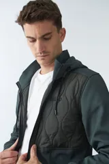 Campera verde oscuro de neopreno con capucha ajustable, cuello alto, bolsillos con cierre y logo en goma.