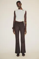 Pantalón marrón acampanado de tiro alto confeccionado en tejido efecto ante con detalle de tachas en la cintura.