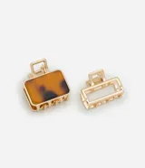 Set de dos pinzas para el pelo rectangulares, una dorada con diseño ahuecado y otra dorada con interior de resina con estampado animal print.