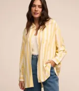 Camisa de viscolino con estampado de rayas verticales amarillas y blancas, corte alargado, cuello inglés, mangas largas y bolsillo en el pecho.
