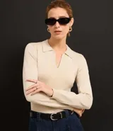 Blusa negra de viscosa con cuello en V con solapa, mangas largas y corte delantero.