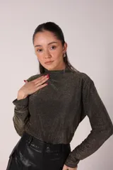 Remera negra de lurex, tipo polera de manga larga con brillos.