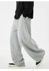 Pantalón de jogging gris de algodón, corte ancho (baggy) y tiro alto, con costura central vertical que recorre la pierna.