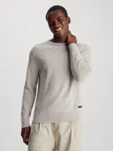 Sweater color gris claro de algodón orgánico con textura slub, cuello redondo, hombros caídos y etiqueta con logo de goma en el bajo.