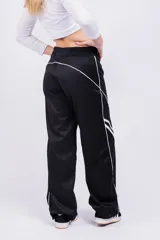 Pantalón deportivo rojo con detalles de líneas blancas curvas en los laterales.