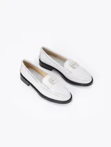 Mocasín de cuero vacuno con efecto gastado en tonos grises y negros. Presenta un aplique metálico con el logo Fire en la vincha y suela grabada con el nombre de la colaboración.