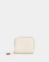 Billetera de cuerina color crema con cierre circundante y puller de cordón y goma. Tiene un tag de metal en relieve con el nombre de la marca.