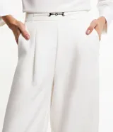 Pantalón pantalona de sastrería color blanco, con cintura elástica en la espalda, detalle metálico delantero y pliegues.