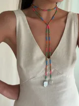 Collar de mostacillas coloridas con diseño largo y terminación de perlas de río, ajustable con cadena y gancho.