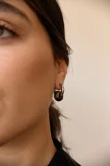 Aros de acero quirúrgico hipoalergénico con forma de argolla plateada y dije circular colgante de piedra natural color azul.