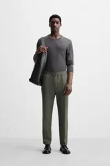 Pantalón color arena de corte recto, confeccionado en tejido elástico. Cuenta con cintura elástica ajustable con cordón, bolsillos laterales y bolsillos de vivo en la parte trasera.