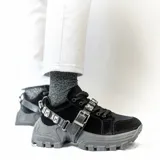 Zapatillas negras aterciopeladas con suela alta y accesorio extraíble con hebillas.